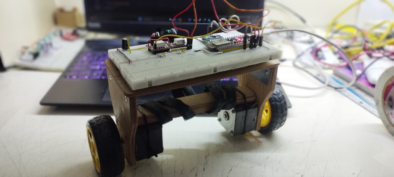 Side view of the robot: wooden chassis, two geared motors, and a breadboard with the ESP32 and motor drivers